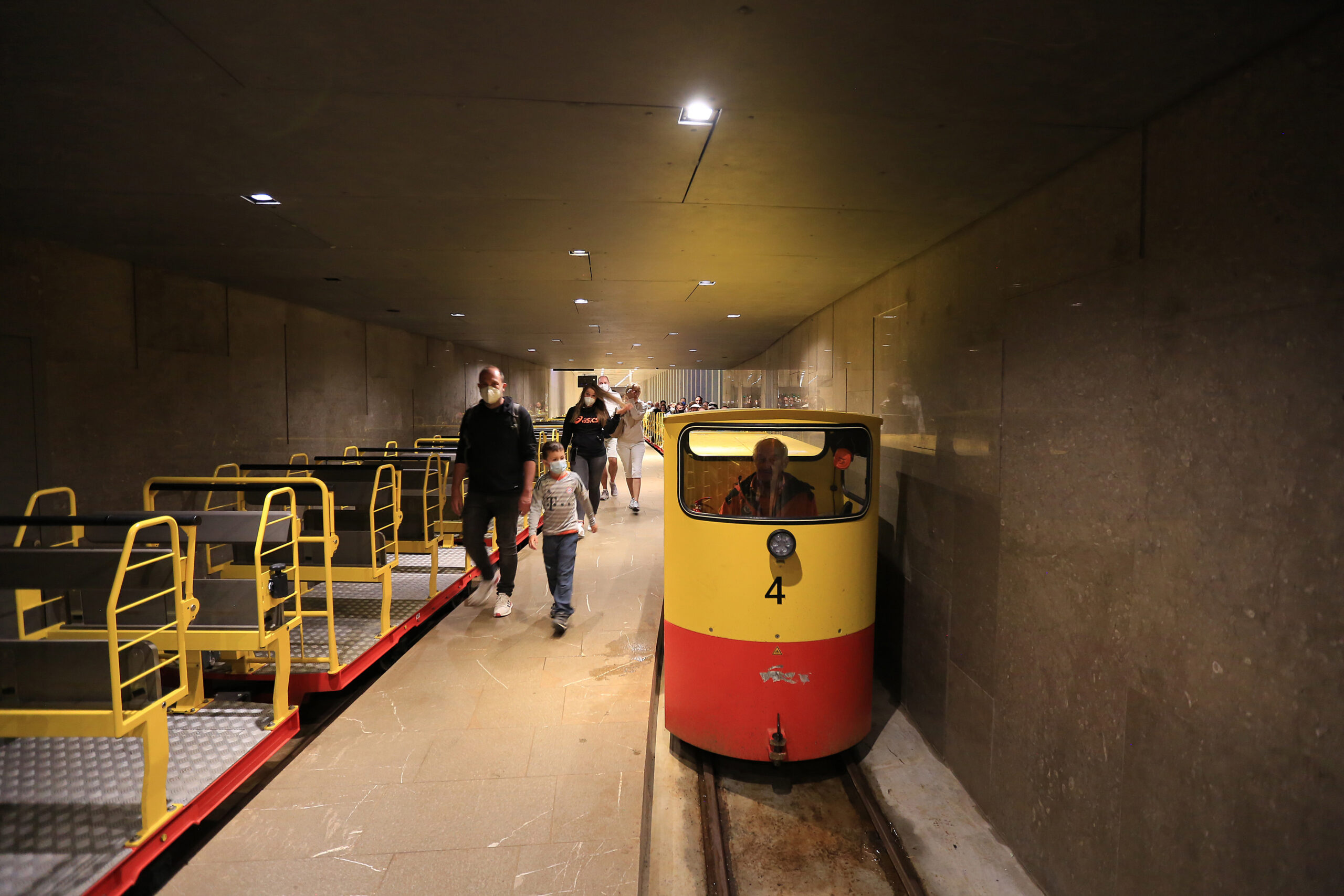 Turistický vláček na kolejích v osvětleném prostoru Postojnské jeskyně